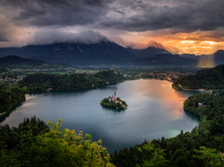 Chmury, Wyspa Blejski Otok, Przebijające światło, Jezioro Bled, Góry Alpy Julijskie, Słowenia, Poranek